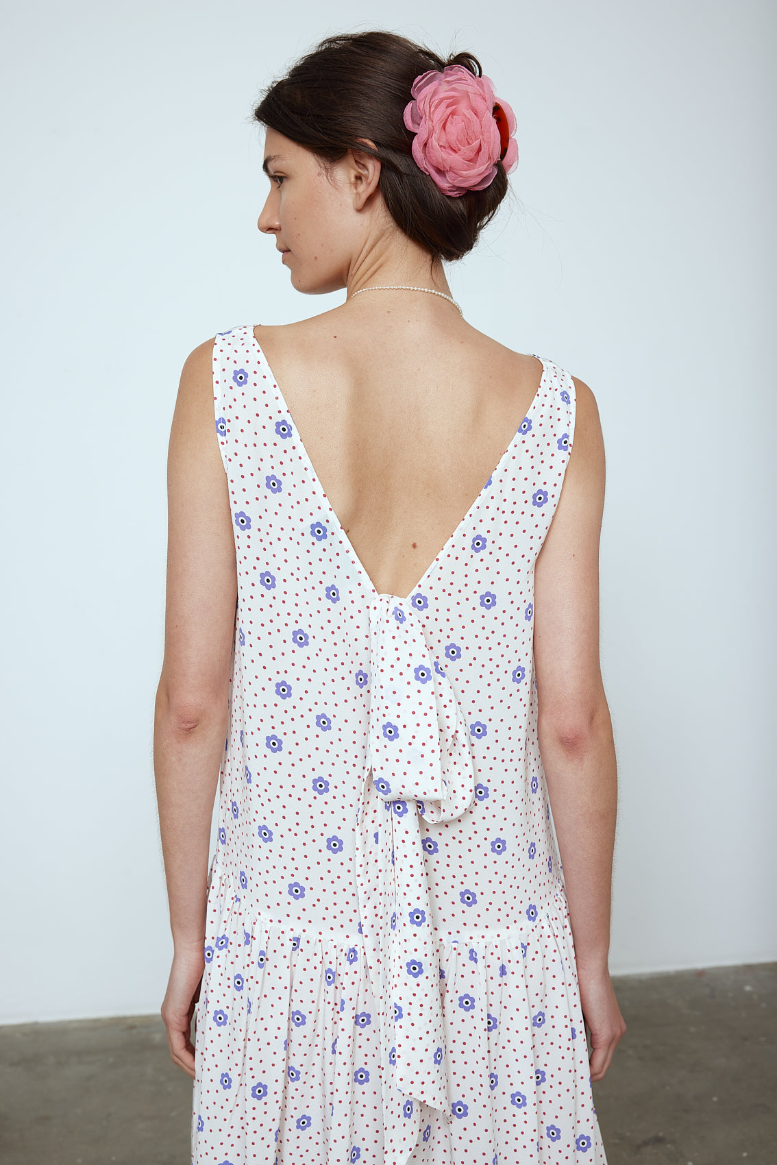 The Sonya Dress is an oversized style with a high neckline and low back featuring a large bow detail. The dress is made from soft mulberry silk featuring a White Daisy print. Style it with an open shirt or denim jacket. Also available in Beaded Emerald Silk Velvet, Navy Flower Poplin, and Black Silk Velvet. Material: 100% cotton.