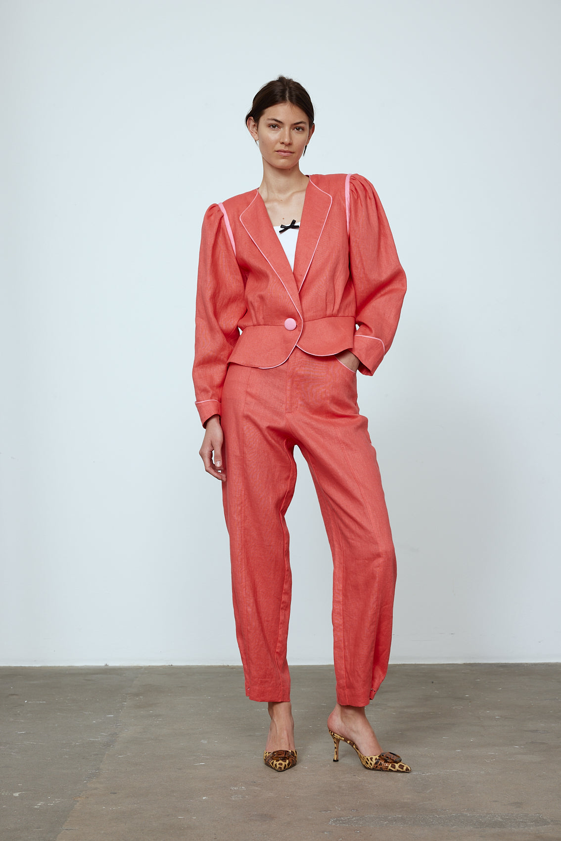 The Emma Pants in Orange Linen. The pants feature cargo details on the side and large pockets with piping details in a contrasting color. Easily modify the shape of the pants with a button adjustment. Style them with a t-shirt, blouse, or a matching Emma Jacket in Orange Linen. Also available in Pink and Navy.