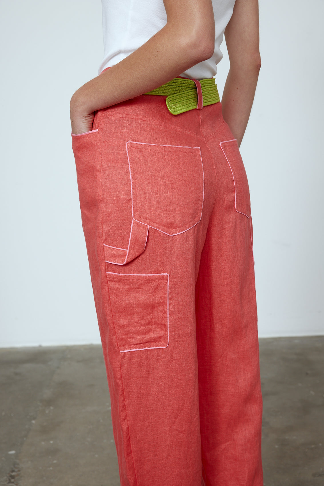 The Emma Pants in Orange Linen. The pants feature cargo details on the side and large pockets with piping details in a contrasting color. Easily modify the shape of the pants with a button adjustment. Style them with a t-shirt, blouse, or a matching Emma Jacket in Orange Linen. Also available in Pink and Navy.