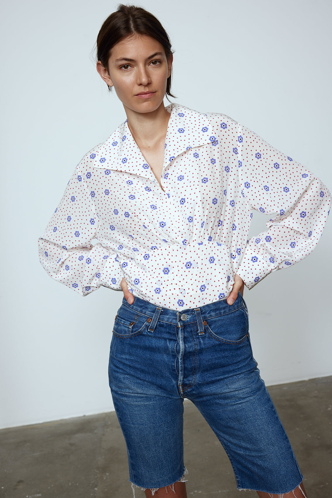 The Nikita Blouse in White Daisy Silk. This shirt features a fitted waist and signature Caro Editions sleeves with cuffs inspired by the party vibe of the 70s. Style it on its own or with a top underneath. Also available in Pale Pink Silk.
