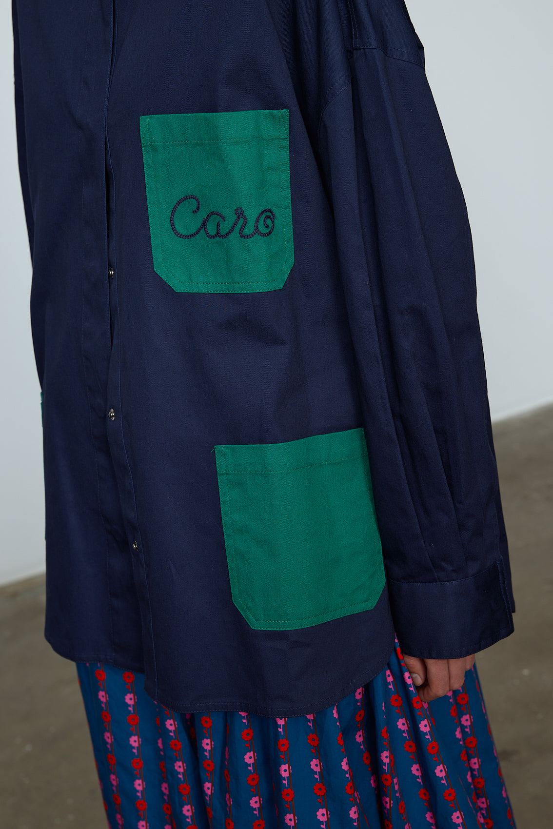 The Frederik Shirt is an oversized cotton style with big sleeves, green pockets, and an embroidered Caro logo on the front. Style it open over a dress, tank top, or t-shirt or buttoned up on its own. Material: 100% cotton. The model is 179cm (5'10") and wears size S.