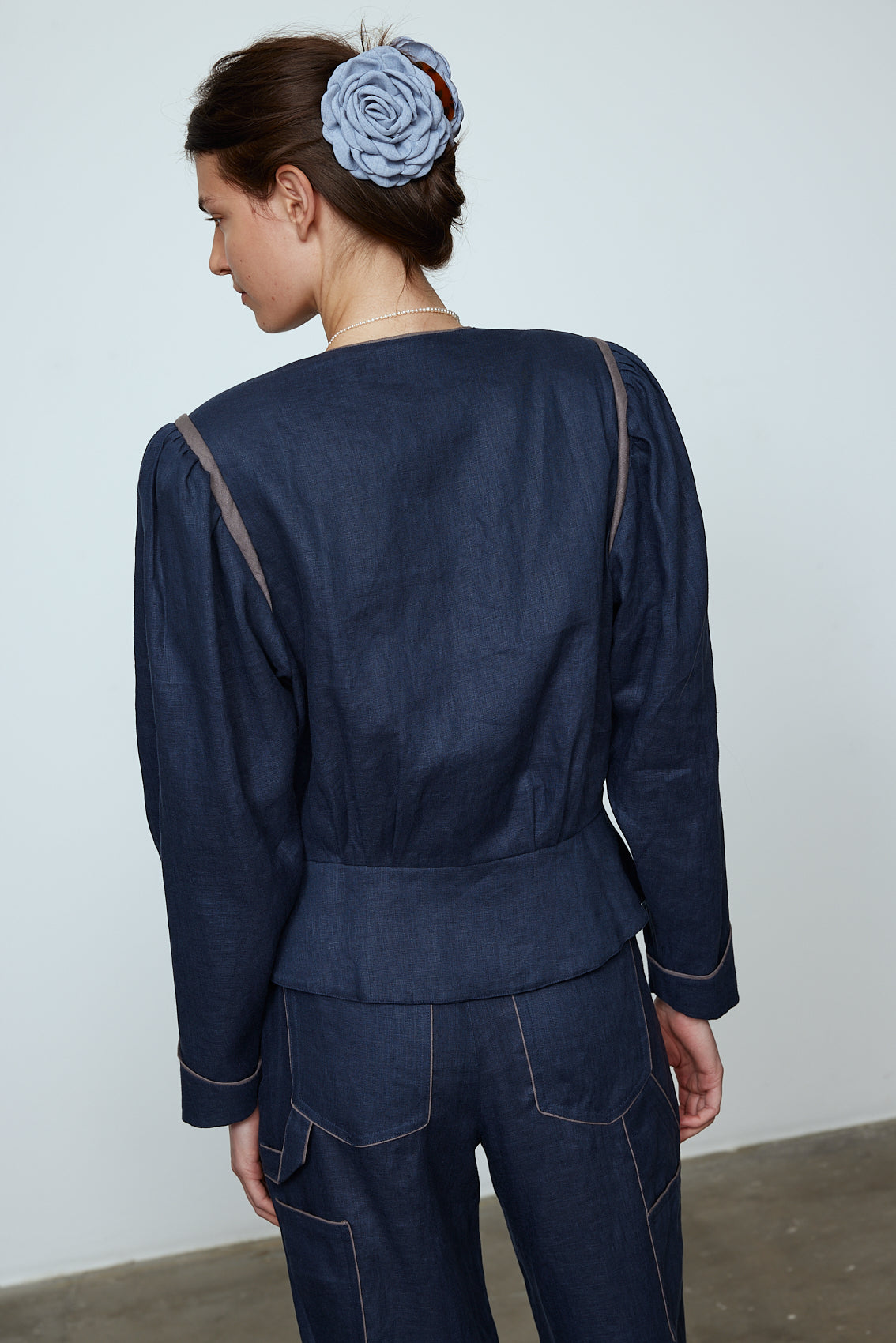 The Emma Jacket in Navy Linen. A new flattering jacket shape inspired by Caroline's favorite vintage 70's finds. The Jacket features a single-button closing, balloon sleeves, and contrasting color piping details around the edges. Also available in Pink/Green and Orange/Pink.
