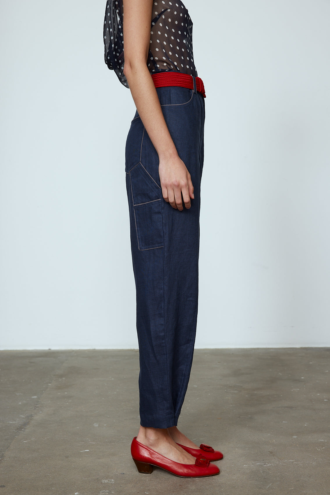 The Emma Pants in Navy Linen. The pants feature cargo details on the side and large pockets with piping details in a contrasting color. Easily modify the shape of the pants with a button adjustment. Style them with a t-shirt, blouse, or a matching Emma Jacket in Navy Linen. Also available in Pink and Orange. Material: 100% linen. Lining: 100% viscose.