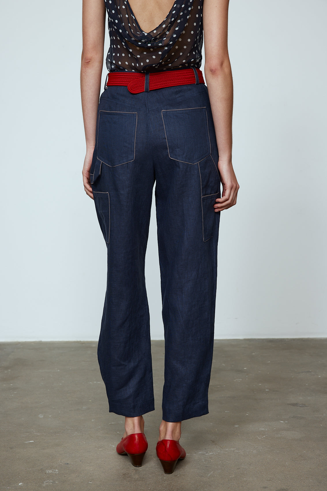 The Emma Pants in Navy Linen. The pants feature cargo details on the side and large pockets with piping details in a contrasting color. Easily modify the shape of the pants with a button adjustment. Style them with a t-shirt, blouse, or a matching Emma Jacket in Navy Linen. Also available in Pink and Orange. Material: 100% linen. Lining: 100% viscose.