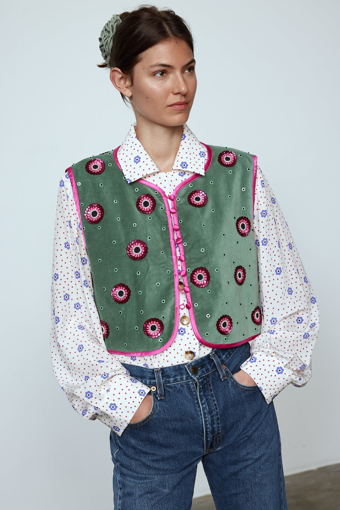 The Ravnbak Vest in Olive Green velvet with a pink lining. The vest is exquisitely hand-embroidered by skilled artisans in our flower daisy pattern using beadings and sequins. Style it over a shirt, dress, or top. Also available in Baby Pink.