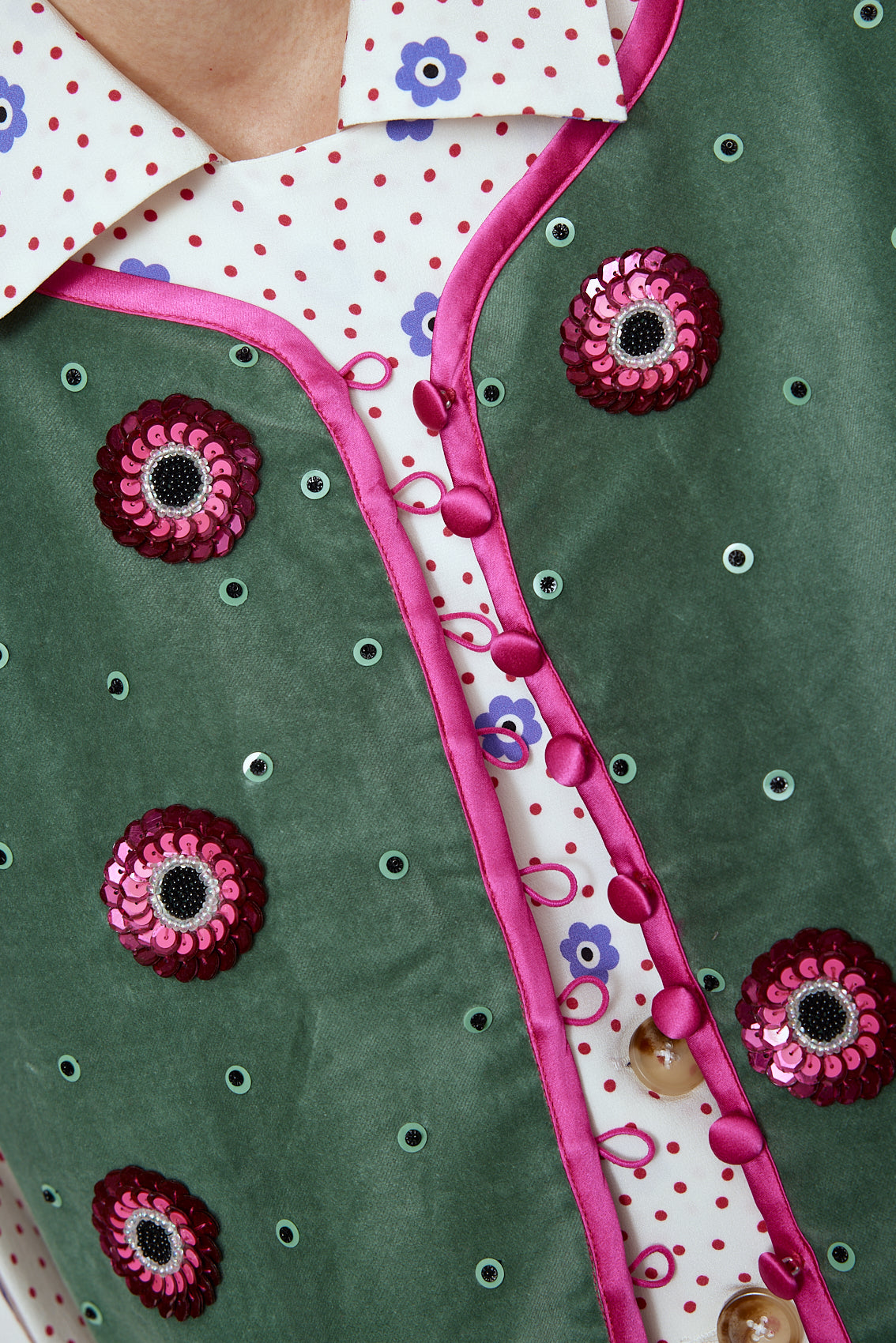 The Ravnbak Vest in Olive Green velvet with a pink lining. The vest is exquisitely hand-embroidered by skilled artisans in our flower daisy pattern using beadings and sequins. Style it over a shirt, dress, or top. Also available in Baby Pink.