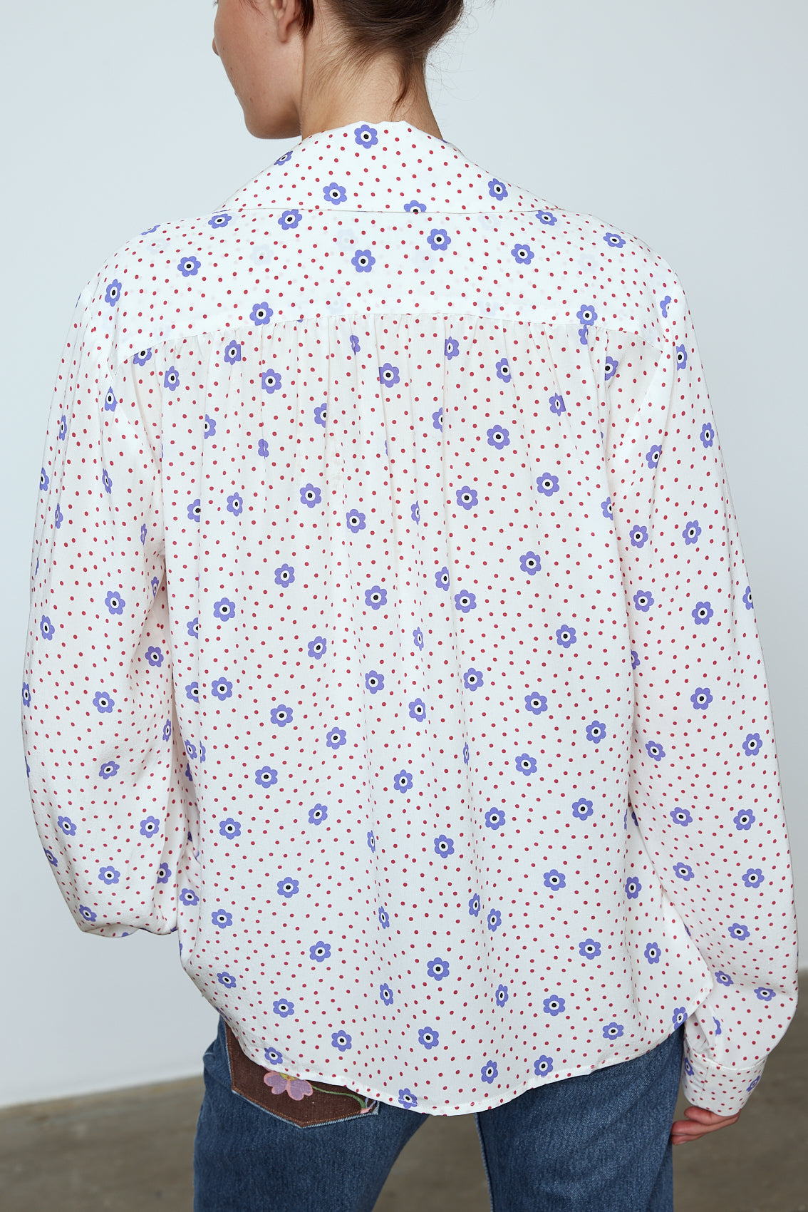 The Bonsai Shirt is made in soft silk fabric featuring our White Daisy print. The Shirt has long draped sleeves, a deep-cut oversized shirt collar, and buttons on the front. Style it with jeans and a colorful belt, together with a vest or denim jacket. Material: 100% mulberry silk. The model is 179cm (5'10") and wears size S.