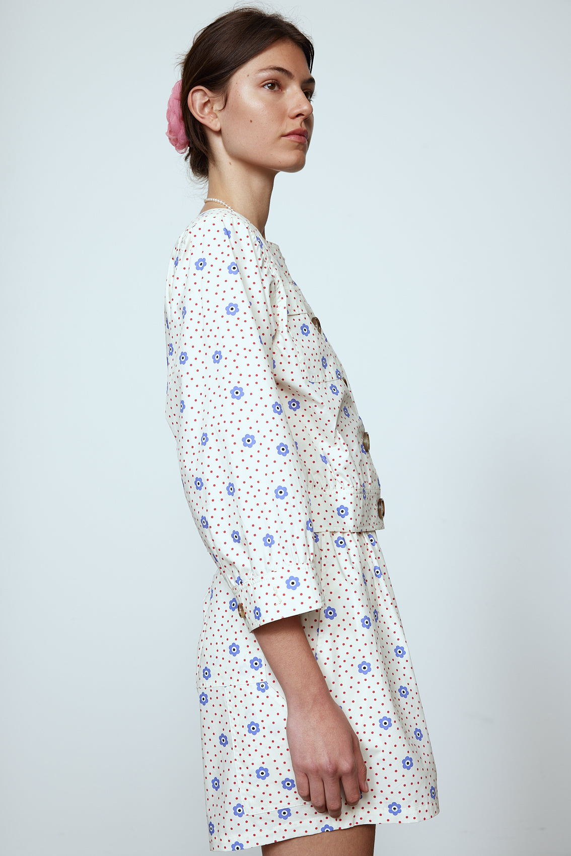 The Aggi Shirt is a new style inspired by Caroline's favorite shapes of the 70s. It features a square-cut neckline, three-quarter-length sleeves, pockets, big contrasting buttons, and a waistband. Material: 100% cotton. The model is 179cm (5'10") and wears size S.