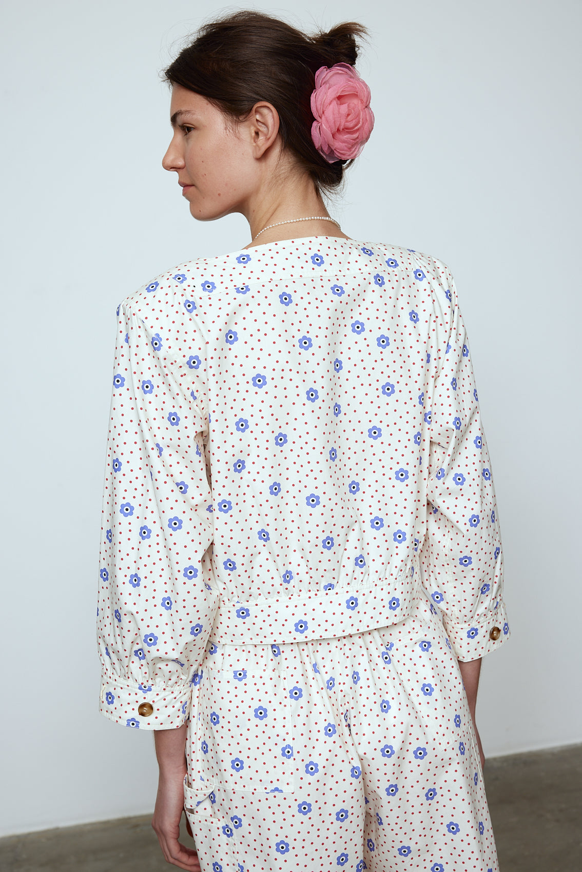 The Aggi Shirt is a new style inspired by Caroline's favorite shapes of the 70s. It features a square-cut neckline, three-quarter-length sleeves, pockets, big contrasting buttons, and a waistband. Material: 100% cotton. The model is 179cm (5'10") and wears size S.