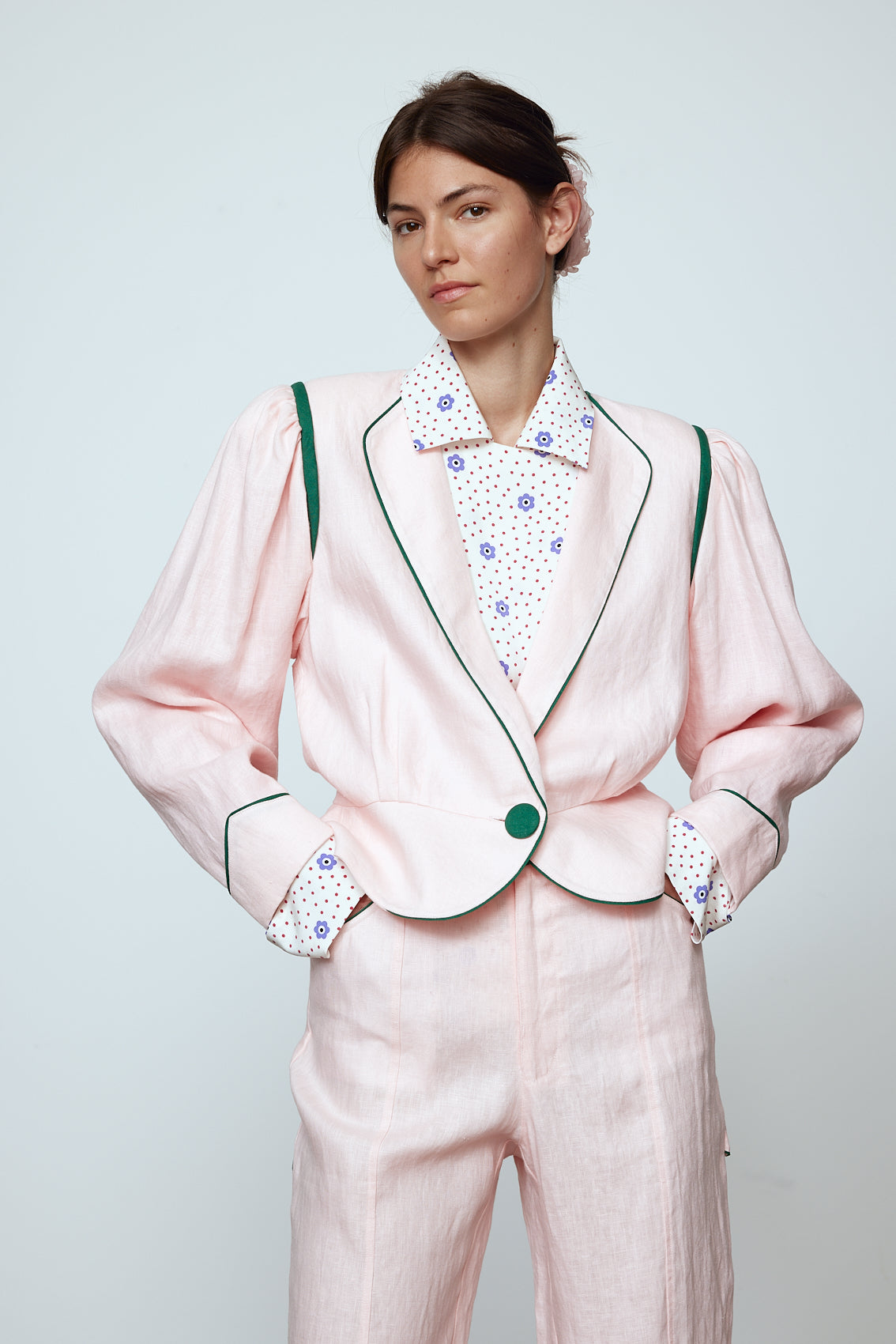 The Emma Jacket in Baby Pink Linen. A new flattering jacket shape inspired by Caroline's favorite vintage 70's finds. The Jacket features a single-button closing, balloon sleeves, and contrasting color piping details around the edges. Also available in Navy and Orange/Pink.