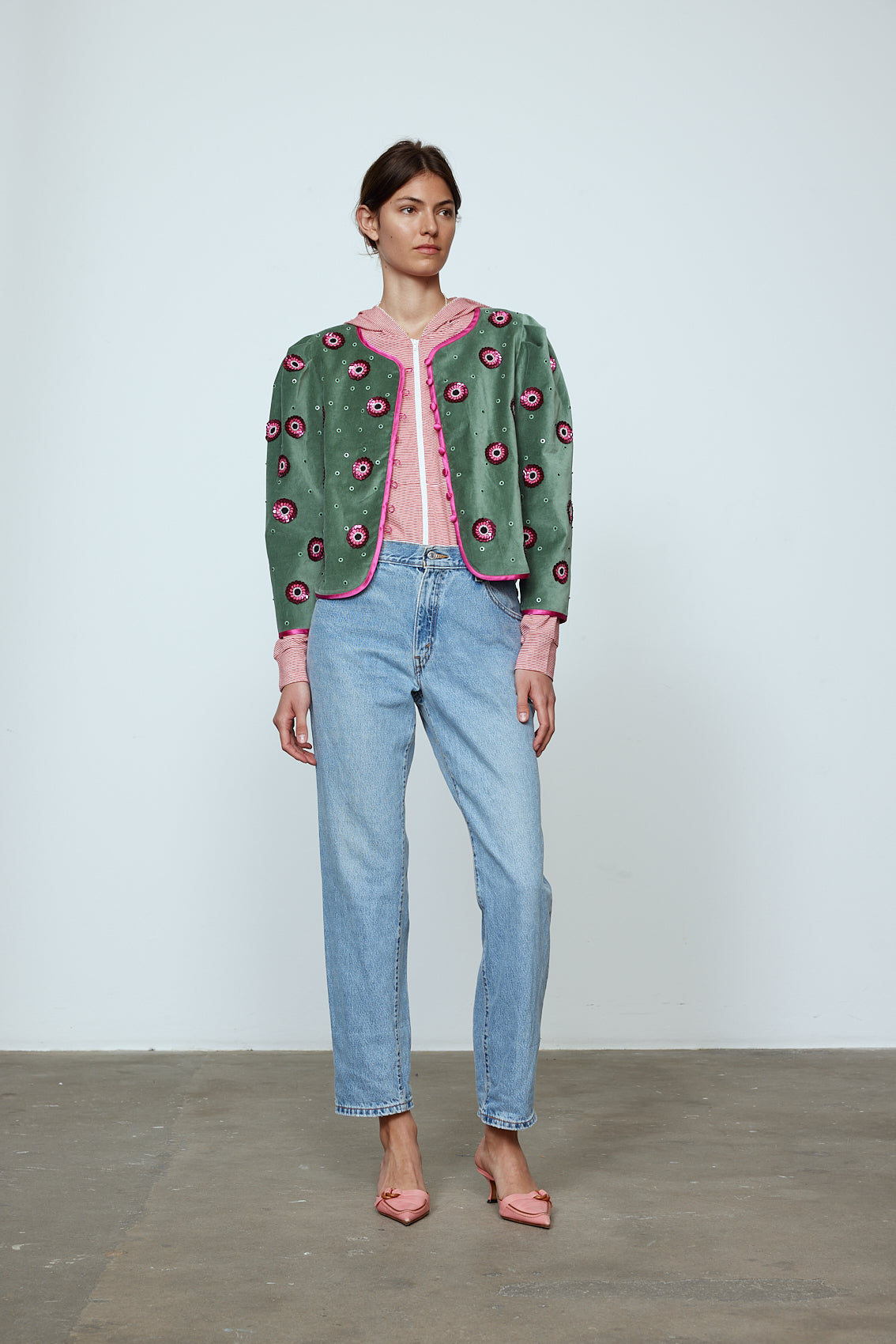 The Blanca Jacket in luxurious olive green silk velvet, exquisitely hand-embroidered by skilled artisans in our flower daisy pattern using beadings and sequins. The jacket features pink silk-button closings on the front and pink silk lining.