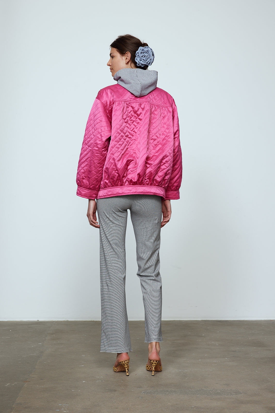 The Mimi Jacket in Hot Pink Duchess. A new rounded shape inspired by the 80s in shiny quilted fabric with orange lining and big round buttons. Style it over dresses, jeans, or leggings. Material: 100% polyester. Lining: 100 % viscose.