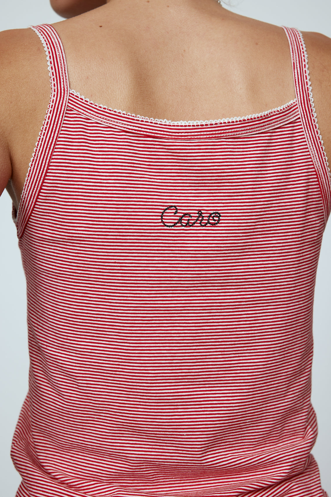 Caro Editions' new signature line in jersey cotton. The Caro Tank is a fitted style with a ribbon bow detail at the front and embroidered Caro Editions logo on the back. Also available in White, Pink White stripe, and Black White stripe. Style the Caro Tank under shirts or dresses, or wear them on their own. Material: 95% cotton, 5% elastane. Bow: 100% Polyester. The model is 179cm (5'10") and wears size S.