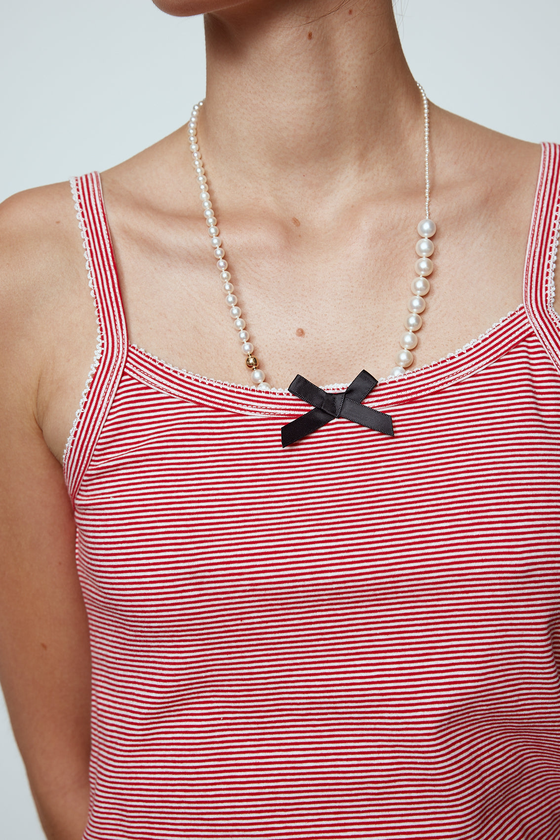 Caro Editions' new signature line in jersey cotton. The Caro Tank is a fitted style with a ribbon bow detail at the front and embroidered Caro Editions logo on the back. Also available in White, Pink White stripe, and Black White stripe. Style the Caro Tank under shirts or dresses, or wear them on their own. Material: 95% cotton, 5% elastane. Bow: 100% Polyester. The model is 179cm (5'10") and wears size S.