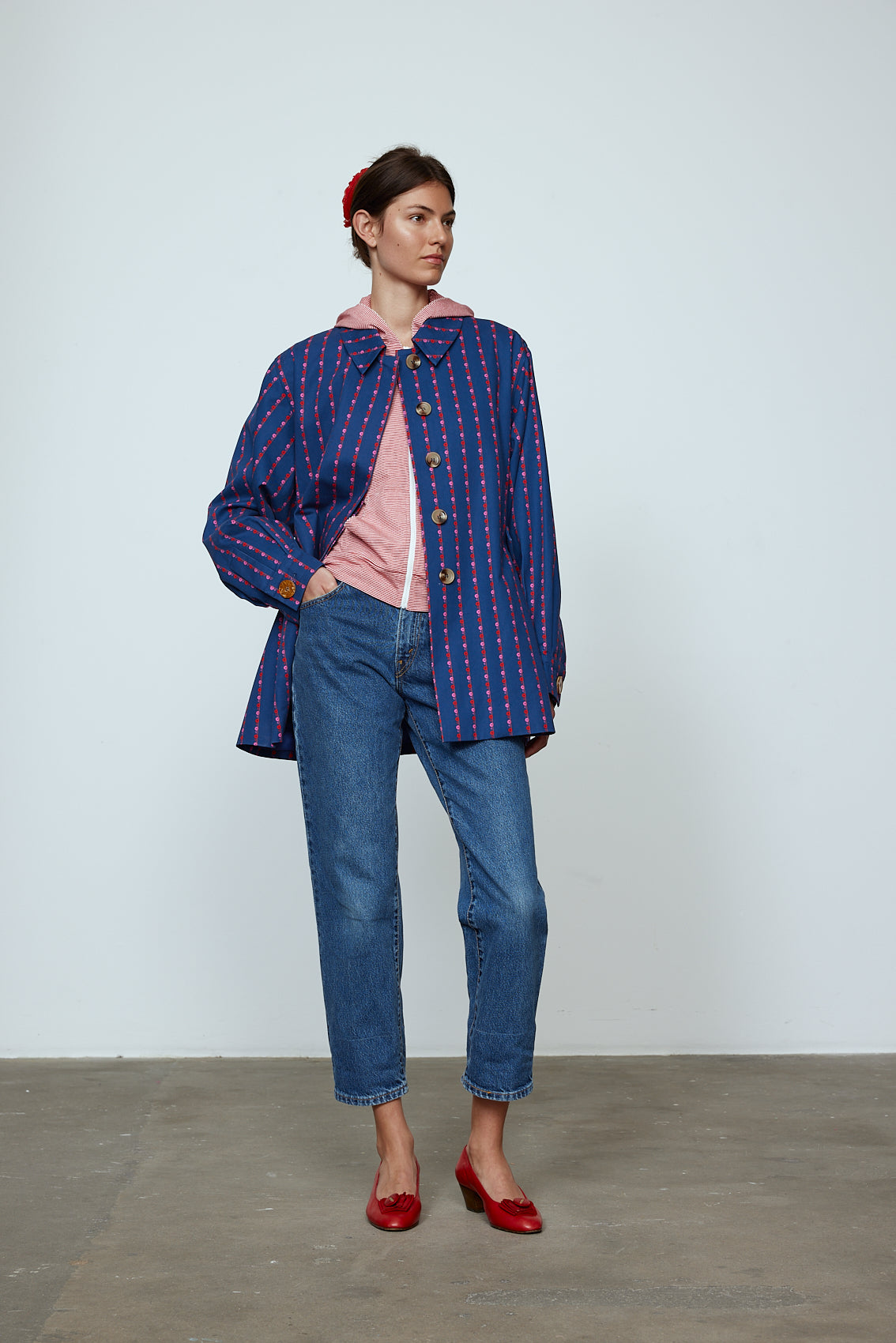 The Ruby Jacket in Navy Flower cotton canvas. A classic Caro Edition style with waist tabs and ornamental buttons. Material: 100% cotton. Lining: 100% viscose.