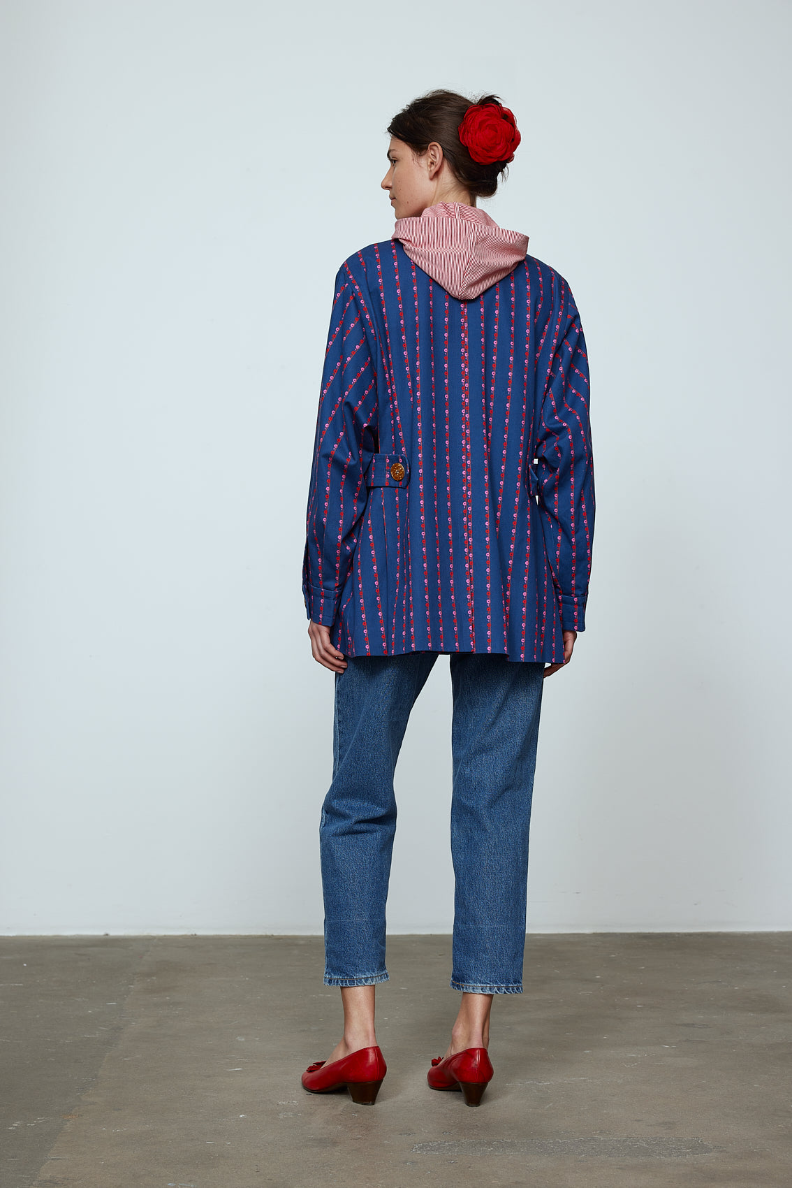 The Ruby Jacket in Navy Flower cotton canvas. A classic Caro Edition style with waist tabs and ornamental buttons. Material: 100% cotton. Lining: 100% viscose.