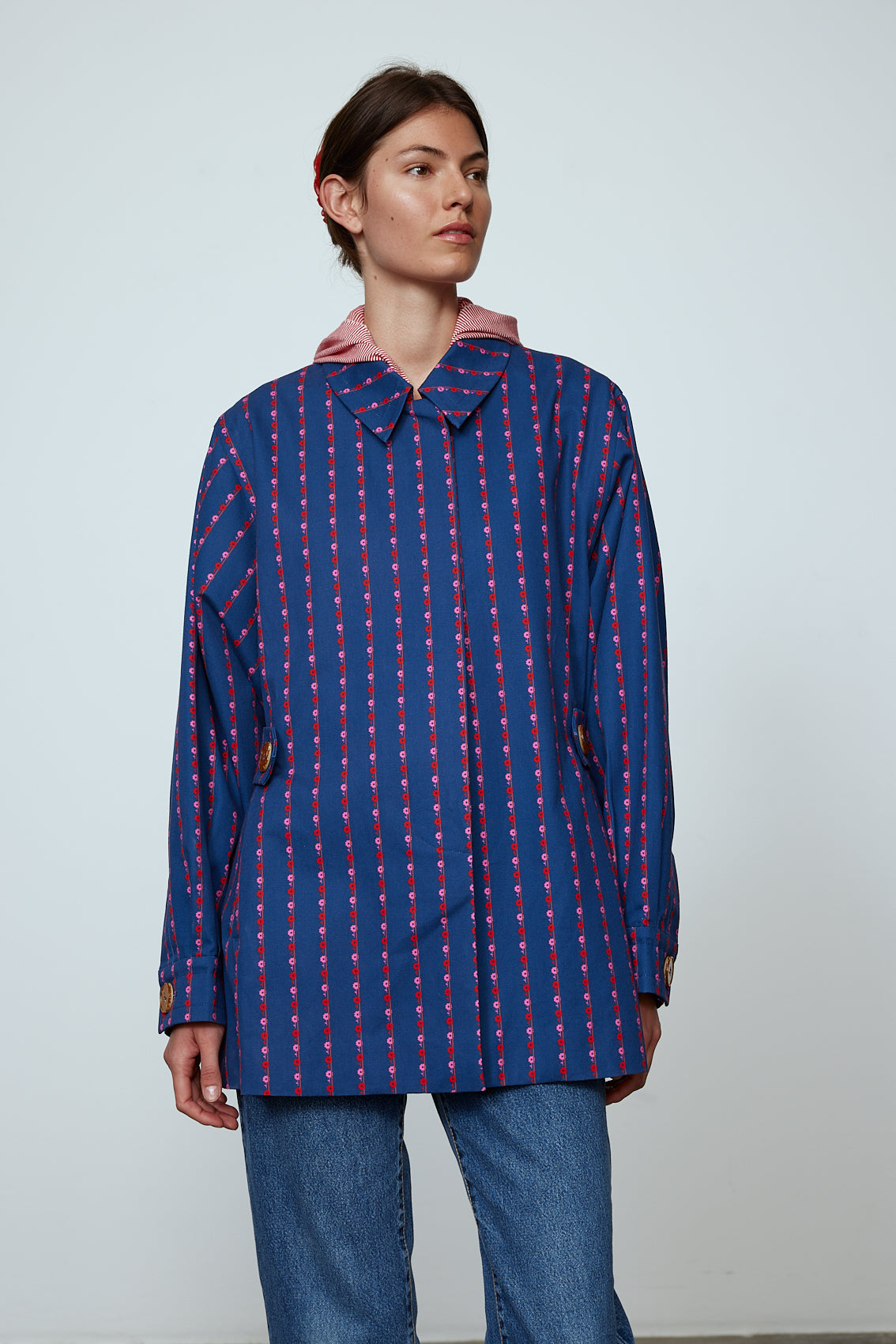 The Ruby Jacket in Navy Flower cotton canvas. A classic Caro Edition style with waist tabs and ornamental buttons. Material: 100% cotton. Lining: 100% viscose.