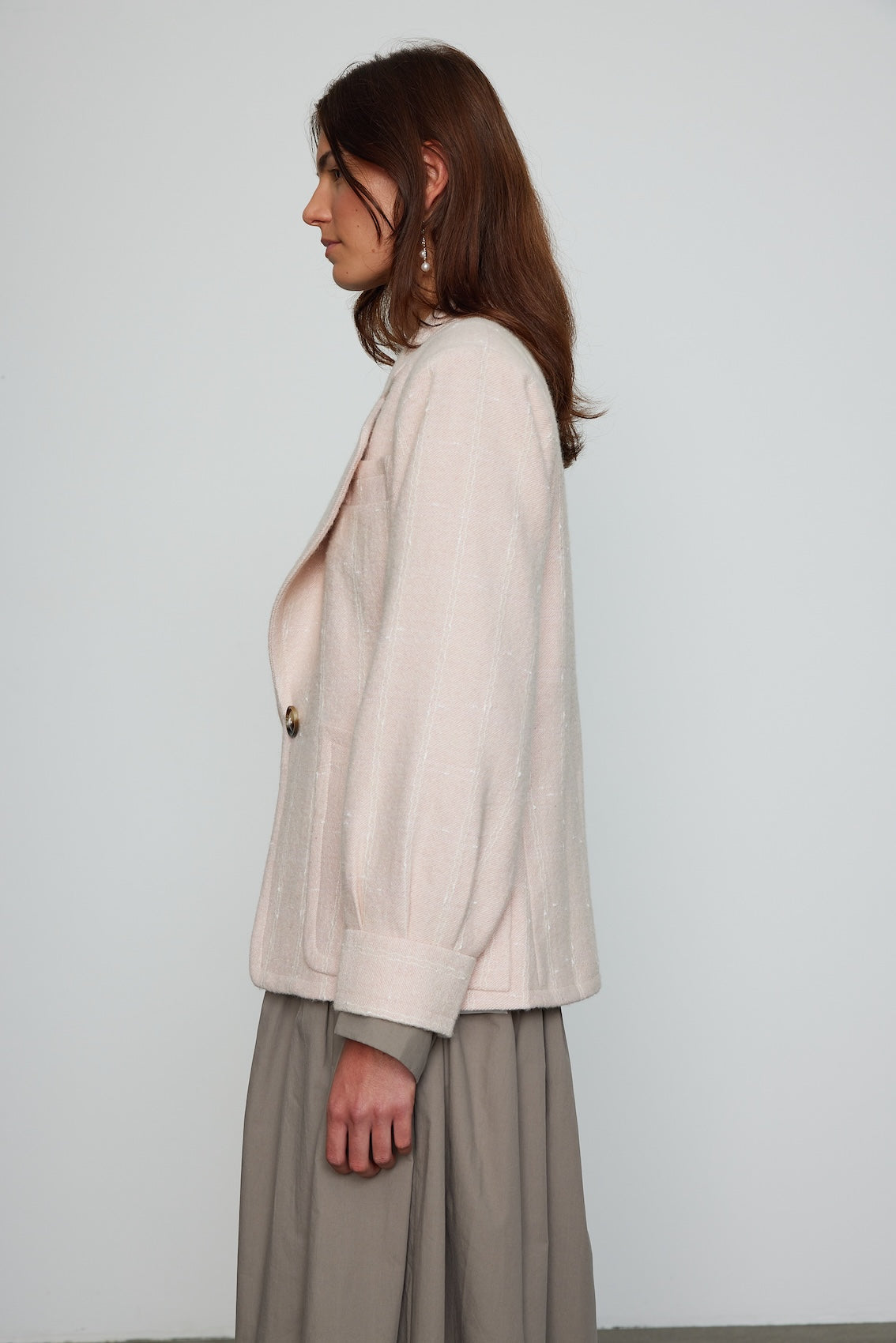 Caro Editions The Annika Jacket in a classic houndstooth tweed The jacket features a single-button closing at the front, wide padded shoulders, and large front pockets. The jacket is slightly fitted around the waist. Material: 100% wool. Lining: 100% viscose.