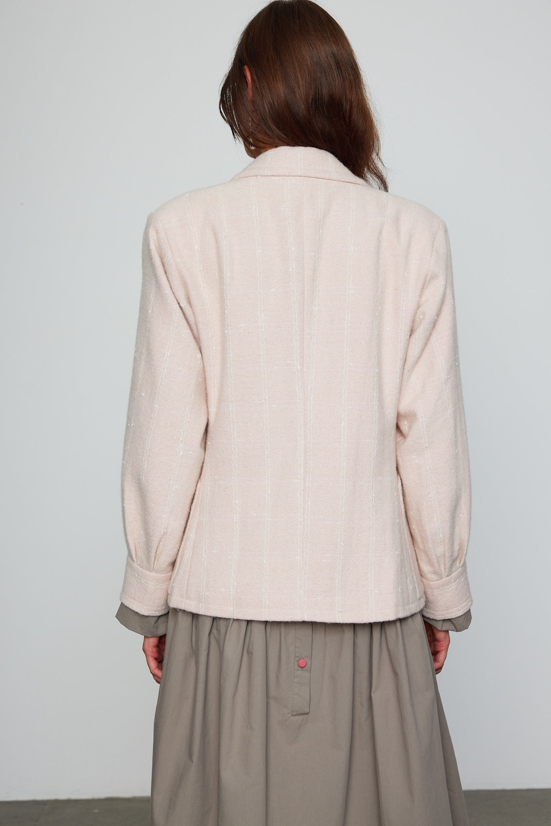 Caro Editions The Annika Jacket in a classic houndstooth tweed The jacket features a single-button closing at the front, wide padded shoulders, and large front pockets. The jacket is slightly fitted around the waist. Material: 100% wool. Lining: 100% viscose.