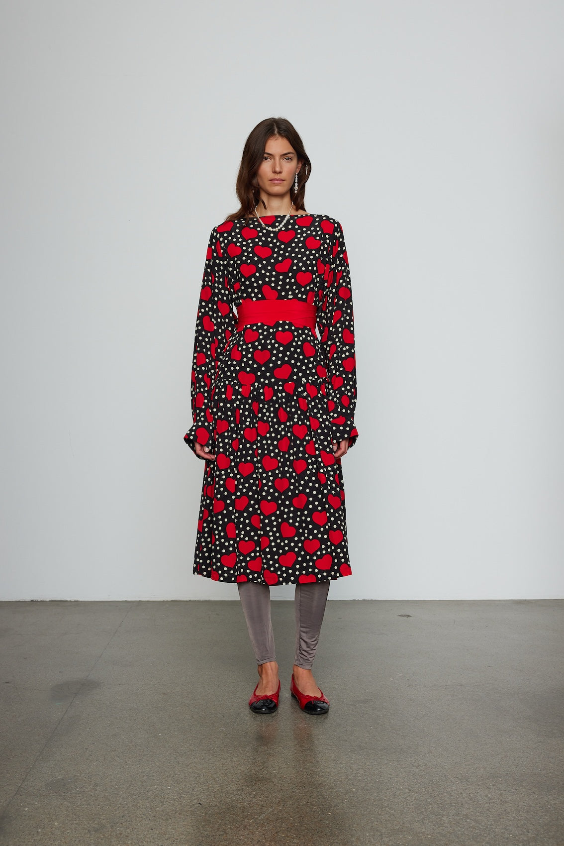 Caro Editions Holly Dress is an oversized style with a high neckline, low back with a large bow detail, and our long draped signature sleeves. The dress is made from soft silk crepe de chine featuring a heart print. Style it with an open shirt or denim jacket.