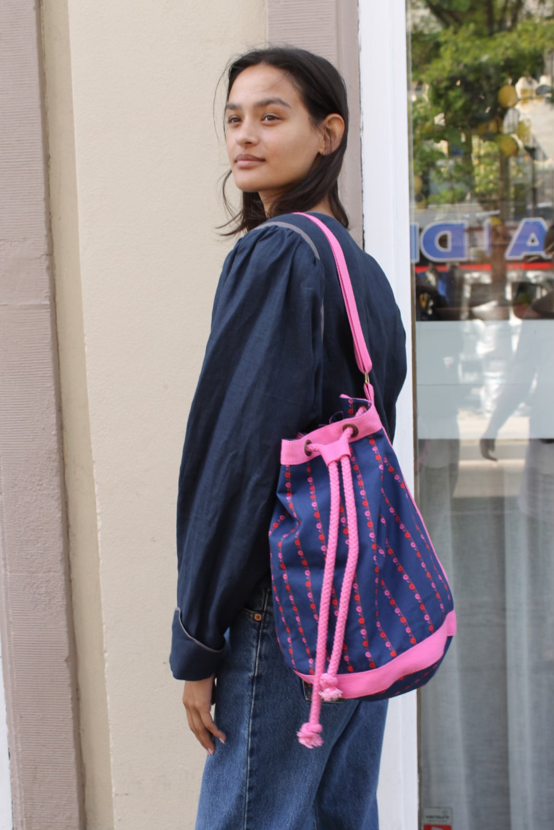 The Large Fern Bag in Navy Flower Canvas with straps and strings in pink.