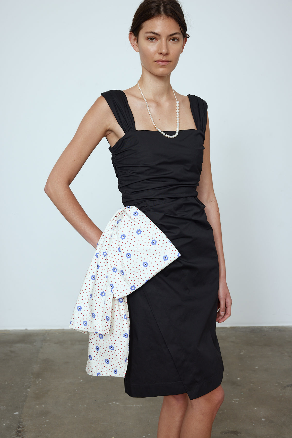 The Sophie Dress is a classic black poplin dress with a big silk bow detail on the side in our blue daisy print. The Dress features wide straps, a slit, and a fitted waist.   Material: 100% cotton. Bow: 100 % silk.  The model is 179cm (5'10") and wears size S.