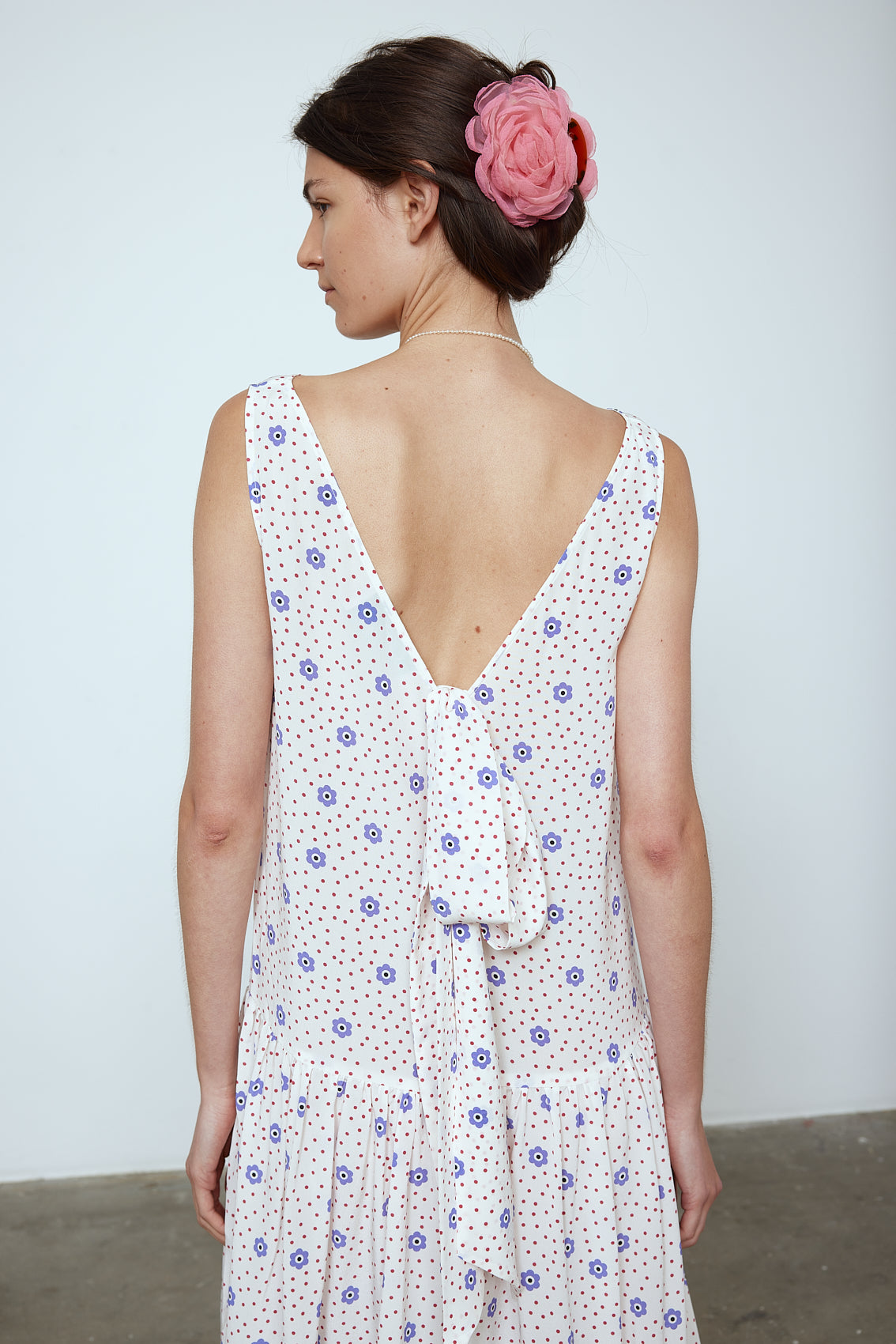 The Sonya Dress is an oversized style with a high neckline and low back featuring a large bow detail. The dress is made from soft mulberry silk featuring a White Daisy print. Style it with an open shirt or denim jacket.  Also available in Beaded Emerald Silk Velvet, Navy Flower Poplin, and Black Silk Velvet.  Material: 100% cotton.