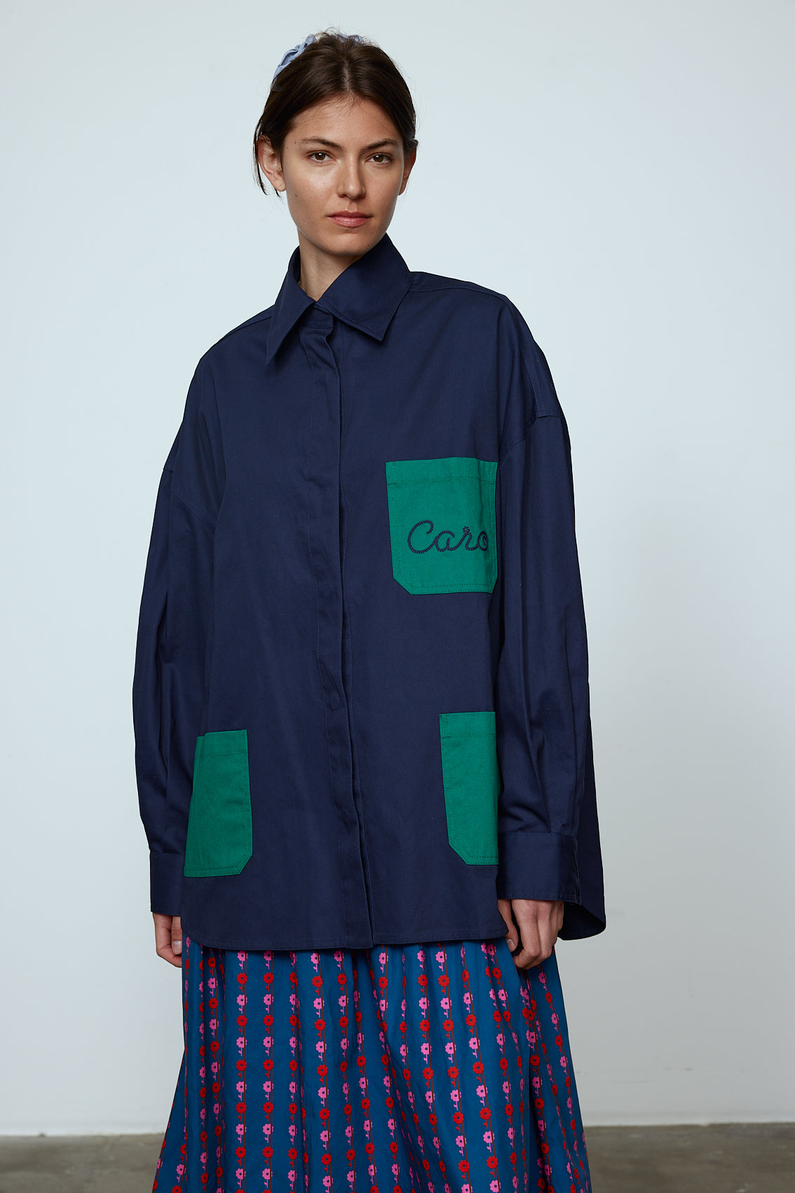 The Frederik Shirt is an oversized cotton style with big sleeves, green pockets, and an embroidered Caro logo on the front.  Style it open over a dress, tank top, or t-shirt or buttoned up on its own.  Material: 100% cotton.  The model is 179cm (5'10") and wears size S. Frederik Bille Brahe.