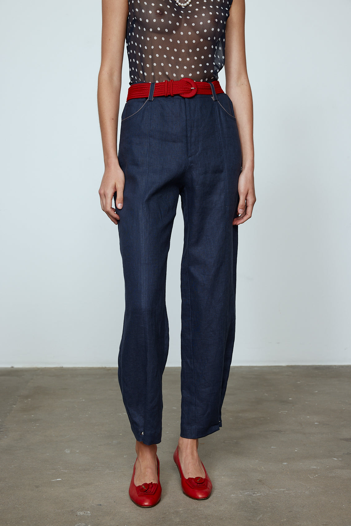 The Emma Pants in Navy Linen. The pants feature cargo details on the side and large pockets with piping details in a contrasting color. Easily modify the shape of the pants with a button adjustment.  Style them with a t-shirt, blouse, or a matching Emma Jacket in Navy Linen.   Also available in Pink and Orange.  Material: 100% linen. Lining: 100% viscose.