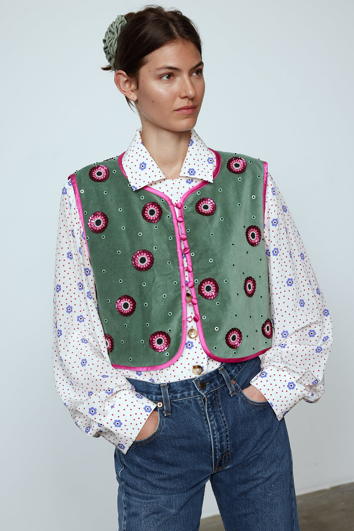 The Ravnbak Vest in Olive Green velvet with a pink lining. The vest is exquisitely hand-embroidered by skilled artisans in our flower daisy pattern using beadings and sequins. Style it over a shirt, dress, or top.  Also available in Baby Pink.