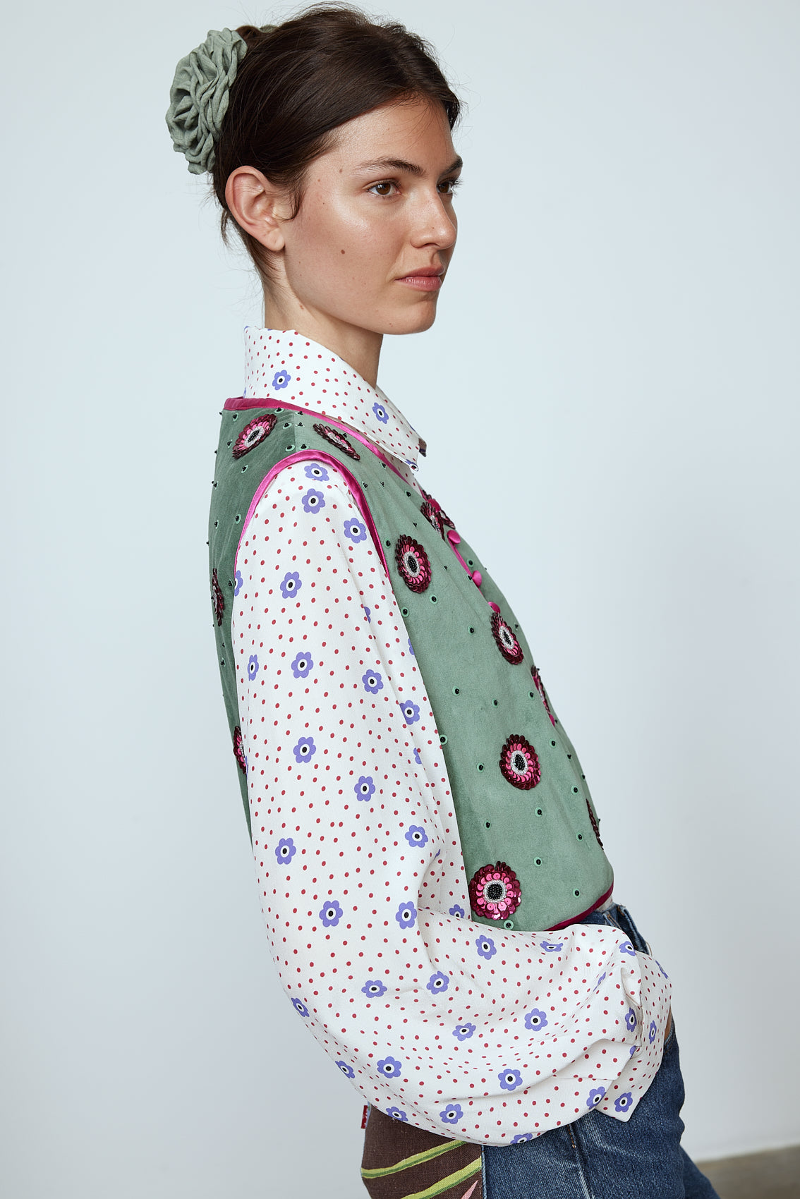 The Ravnbak Vest in Olive Green velvet with a pink lining. The vest is exquisitely hand-embroidered by skilled artisans in our flower daisy pattern using beadings and sequins. Style it over a shirt, dress, or top.  Also available in Baby Pink.