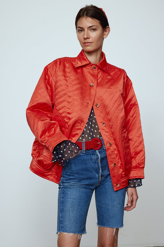 The Mimi Jacket in Orange Duchess. A new rounded shape inspired by the 80s in shiny quilted fabric with orange lining and big round buttons.  Style it over dresses, jeans, or shorts.   Material: 100% polyester. Lining: 100% viscose.