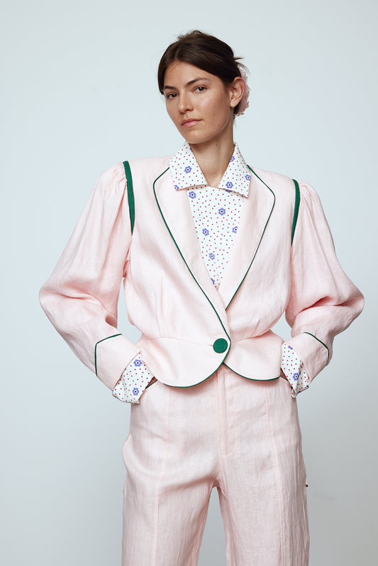 The Emma Jacket in Baby Pink Linen. A new flattering jacket shape inspired by Caroline's favorite vintage 70's finds. The Jacket features a single-button closing, balloon sleeves, and contrasting color piping details around the edges.   Also available in Navy and Orange/Pink.
