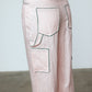 The Emma Pants in Baby Pink Linen. The pants feature cargo details on the side and large pockets with piping details in a contrasting color. Easily modify the shape of the pants with a button adjustment.  Style them with a t-shirt, blouse, or a matching Emma Jacket in Baby Pink Linen.   Also available in Orange and Navy.