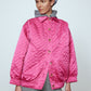 The Mimi Jacket in Hot Pink Duchess. A new rounded shape inspired by the 80s in shiny quilted fabric with orange lining and big round buttons.  Style it over dresses, jeans, or leggings.   Material: 100% polyester. Lining: 100 % viscose.