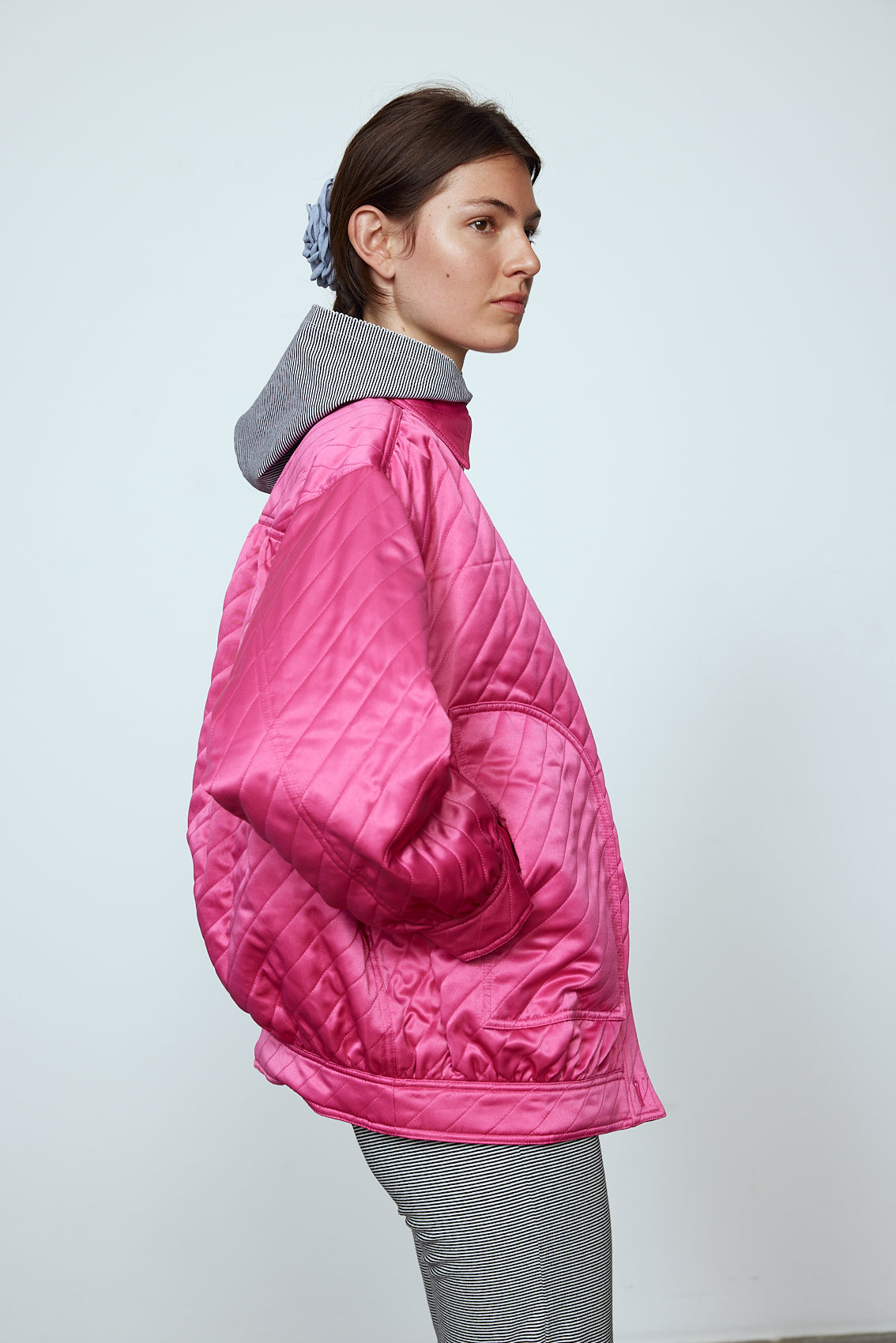 The Mimi Jacket in Hot Pink Duchess. A new rounded shape inspired by the 80s in shiny quilted fabric with orange lining and big round buttons.  Style it over dresses, jeans, or leggings.   Material: 100% polyester. Lining: 100 % viscose.
