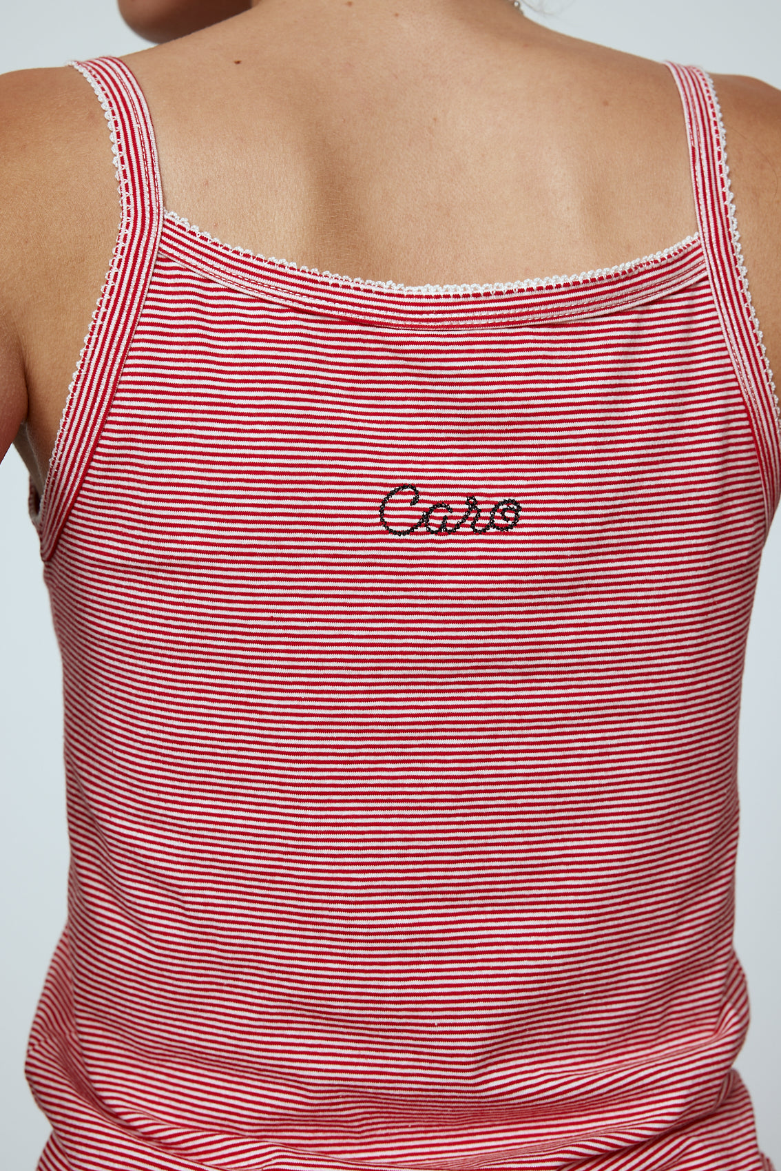 Caro Editions' new signature line in jersey cotton.  The Caro Tank is a fitted style with a ribbon bow detail at the front and embroidered Caro Editions logo on the back.   Also available in White, Pink White stripe, and Black White stripe.  Style the Caro Tank under shirts or dresses, or wear them on their own.  Material: 95% cotton, 5% elastane. Bow: 100% Polyester.  The model is 179cm (5'10") and wears size S.