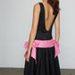 Caro Editions Margrethe Dress is a fitted style made from black linen with a round neckline, low back, drop waist and a draped skirt for extra volume. The half belt on this dress features side bows in pink linen. Material: 100% Silk.