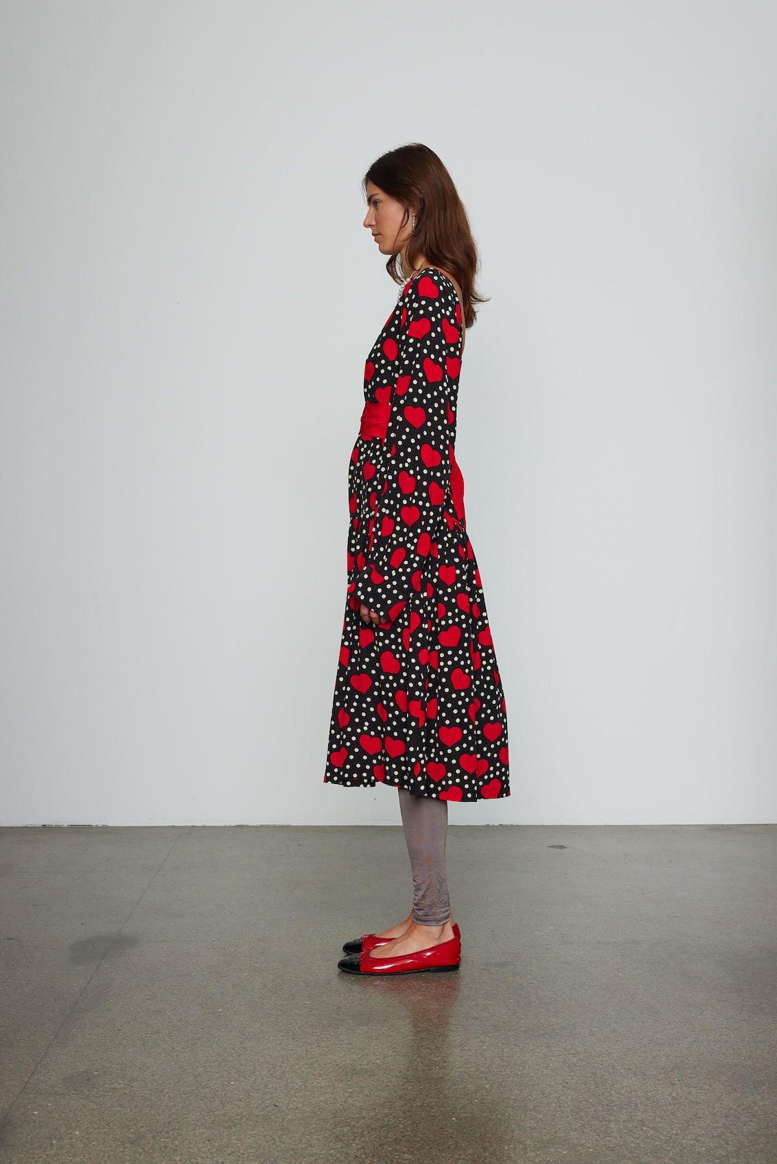 Caro Editions Holly Dress is an oversized style with a high neckline, low back with a large bow detail, and our long draped signature sleeves. The dress is made from soft silk crepe de chine featuring a heart print. Style it with an open shirt or denim jacket.