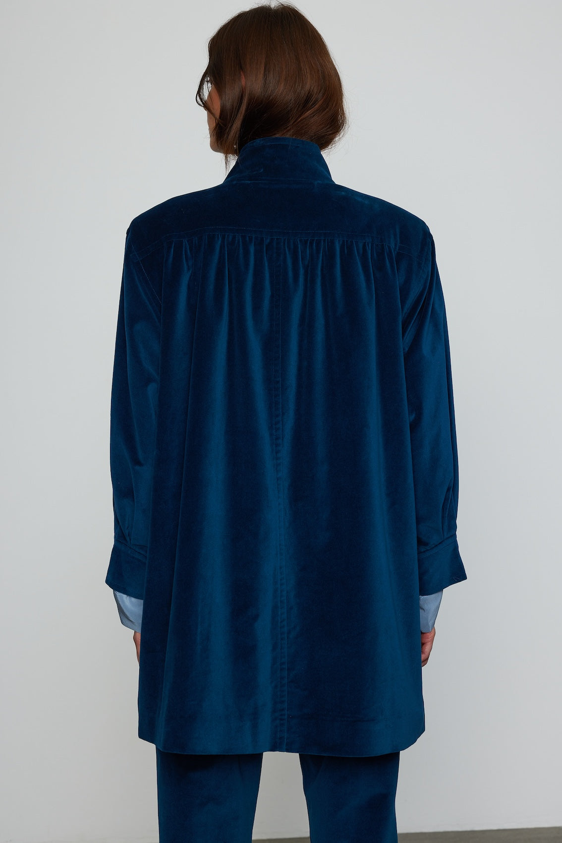 Caro Editions Gaia Coat is a new Caro Editions style made in a rich blue cotton velvet. The coat is loose fitting, long, square wide shoulders with a light shoulder pad and horn buttons. Wear it open or closed over your outfit, or match it with Annika Pants in Brown cotton velvet to create a statement suit, or style casually with jeans.