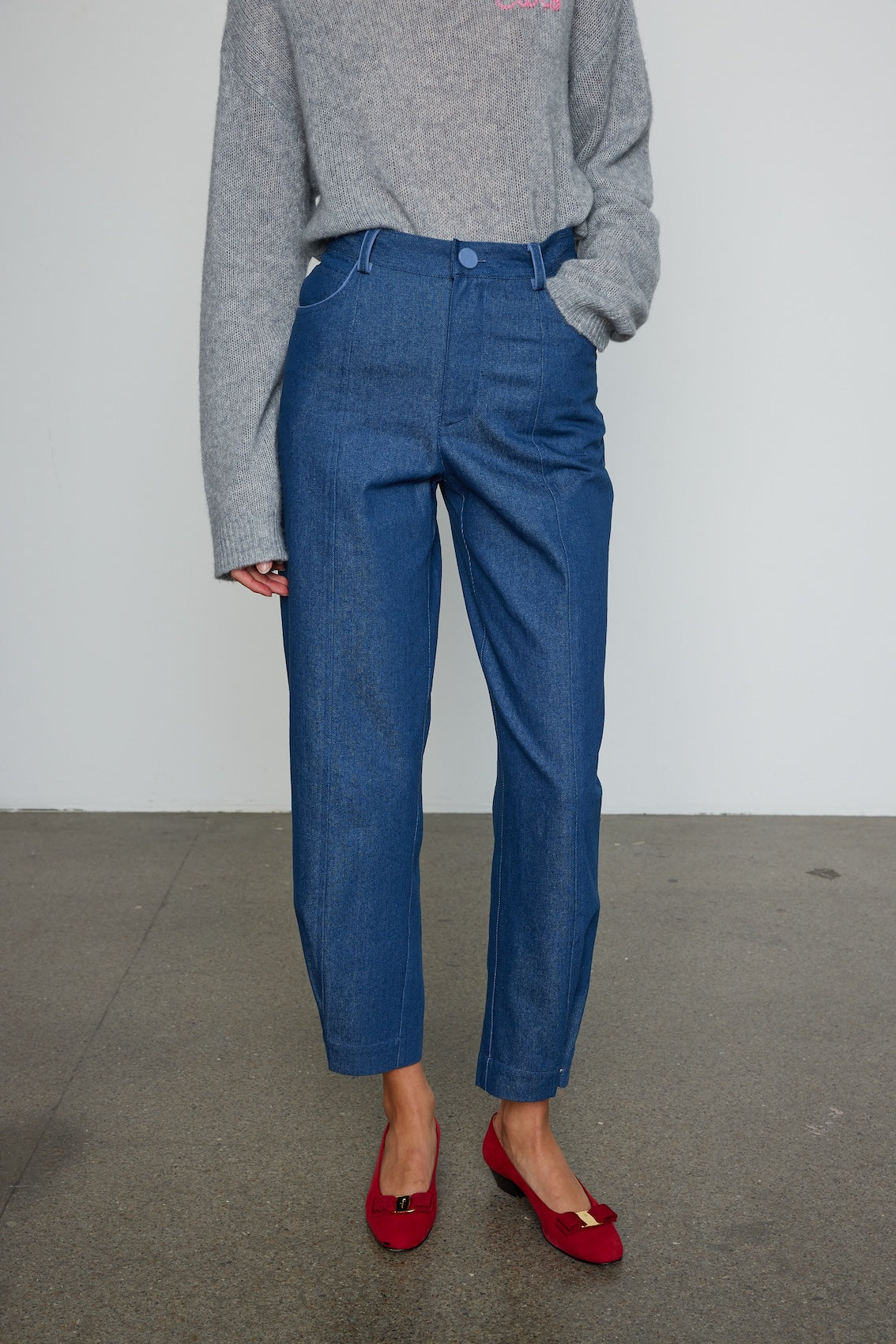 Caro Editions Emma Pants in Indigo Denim. The pants feature cargo details on the side and large pockets with piping details in a contrasting color. Easily modify the shape of the pants with a button adjustment. Style them with a t-shirt, blouse, or a matching Emma Jacket.