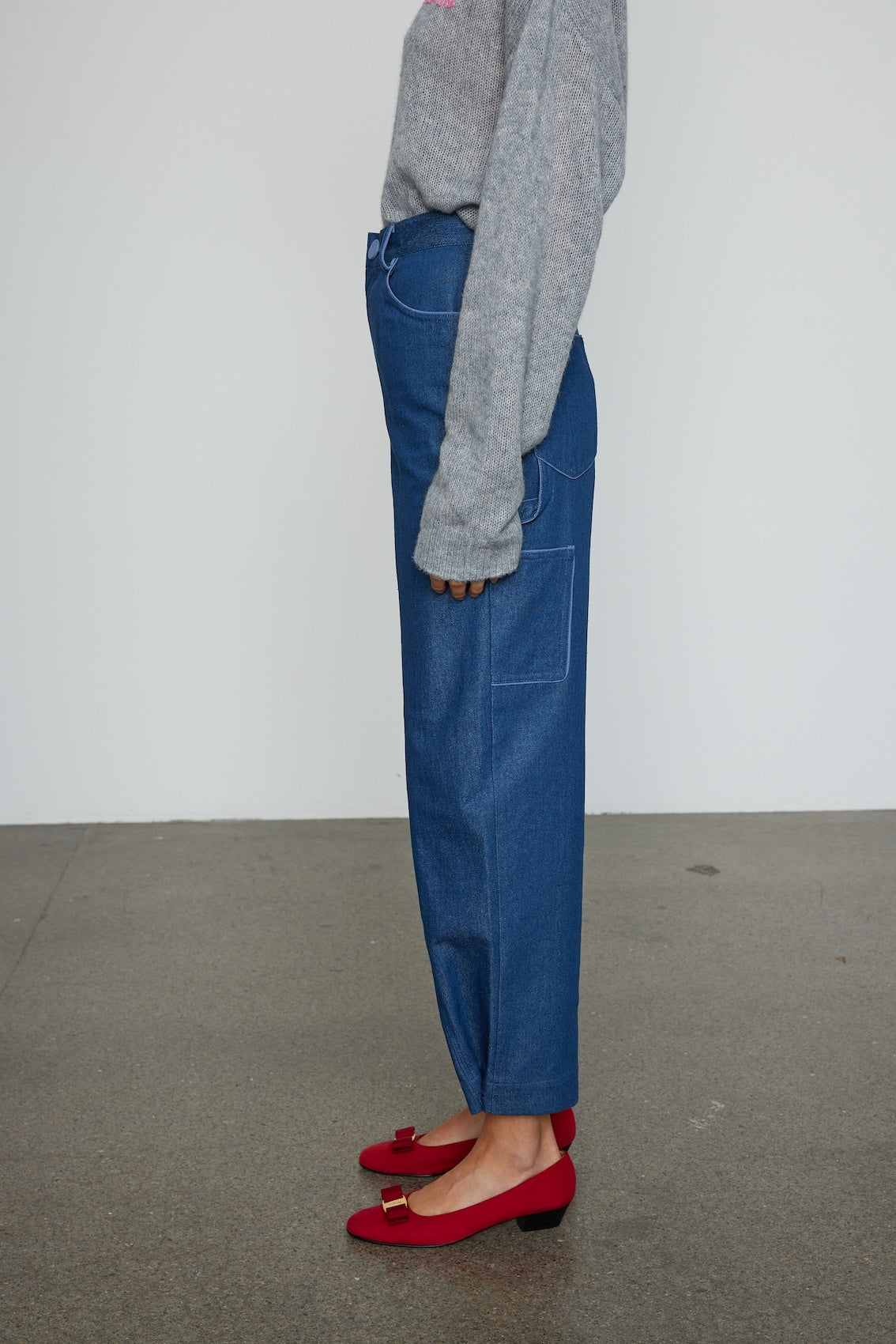 Caro Editions Emma Pants in Indigo Denim. The pants feature cargo details on the side and large pockets with piping details in a contrasting color. Easily modify the shape of the pants with a button adjustment. Style them with a t-shirt, blouse, or a matching Emma Jacket.