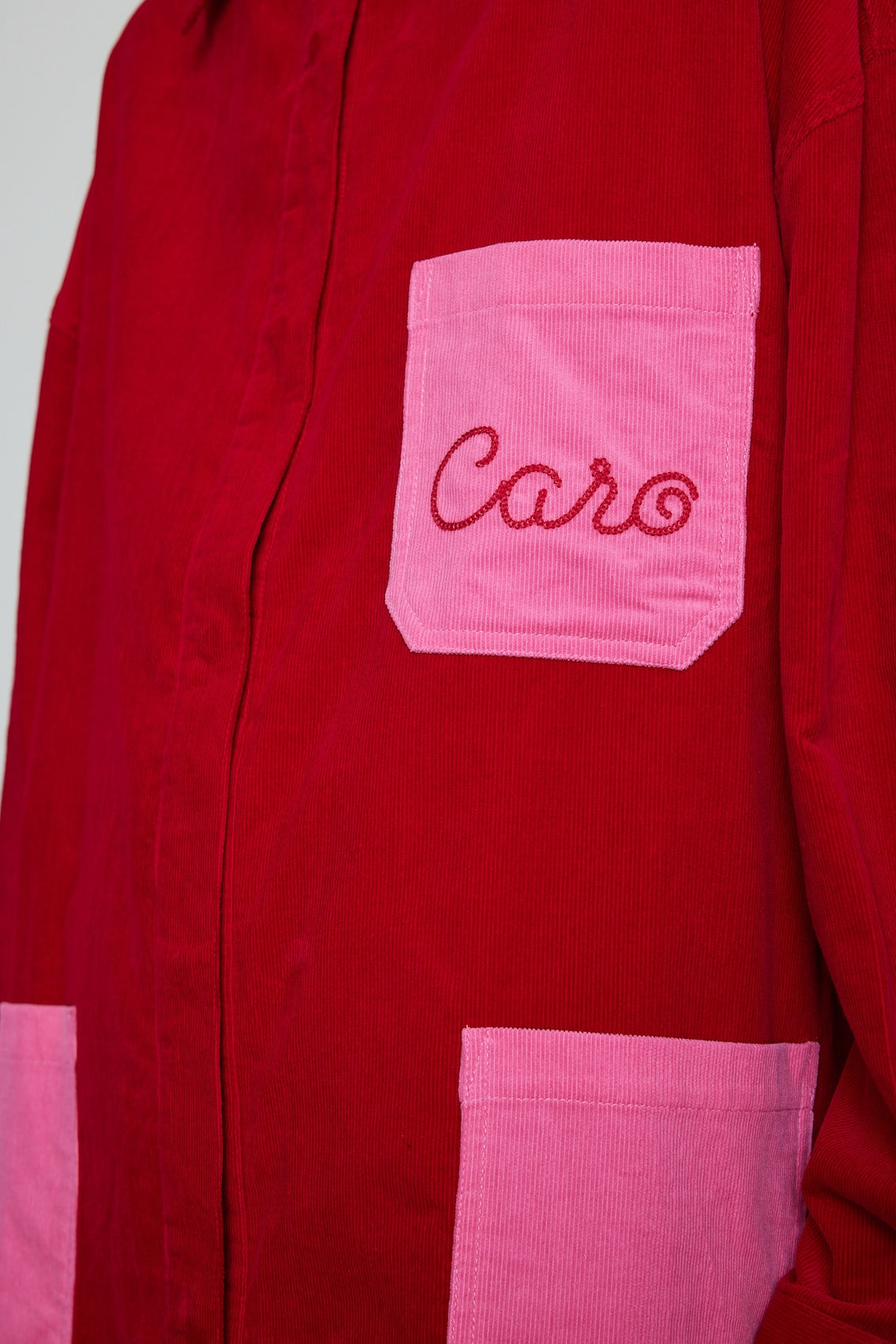 Caro Editions Frederik Shirt is an oversized cotton corduroy style with big sleeves, pink pockets, and an embroidered Caro logo. Style it open over a dress, tank top, or t-shirt, or wear it buttoned-up.