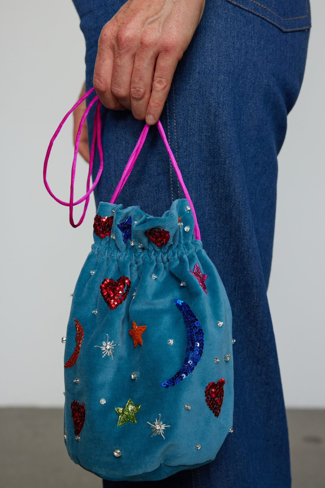 Caro Editions Mini Bucket Bag in silk velvet is exquisitely hand-embroidered by skilled artisans using beads and sequins.  Material: 100% Cotton. Lining: 100% Silk. Beading: Polyester & Glass.