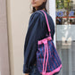 The Large Fern Bag in Navy Flower Canvas with straps and strings in pink.
