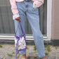 The Small Fern Bag in White Daisy cotton canvas with straps and strings in purple.  Also available as Large Fern Bag - Navy Flower Canvas.