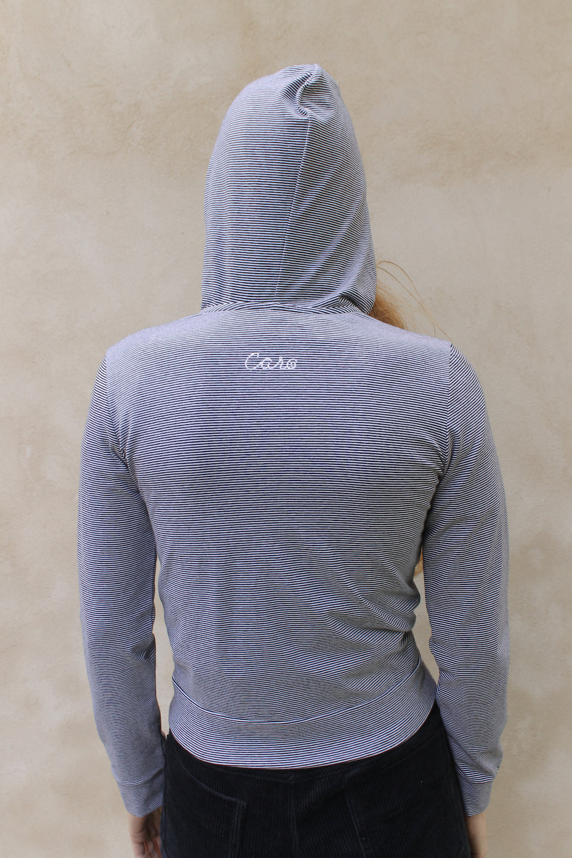 Caro Editions' new signature line in jersey cotton.  The Caro PJ Hoodie is a slightly fitted style with long sleeves, a zipper opening on the front, and embroidered Caro Editions logo on the back.   Also available in Red White stripe.  Style the Caro PJ Hoodie under a jacket or shirt, with matching Caro PJ Leggings, jeans, or a skirt.  Material: 95% cotton, 5% elastane. Bow: 100% Polyester.  The model is 179cm (5'10") and is wearing a size S.