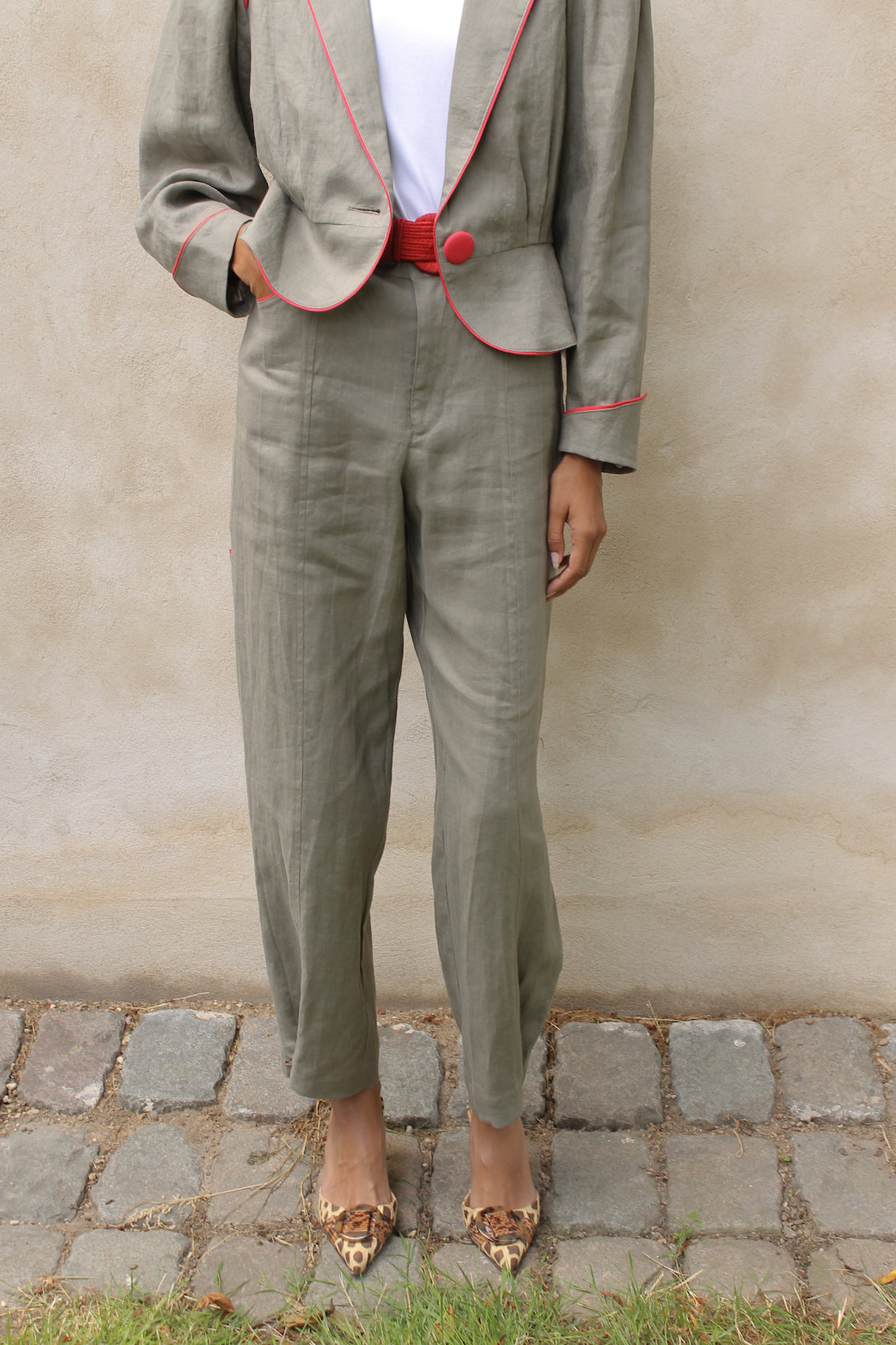 The Emma Pants in Khaki Linen. The pants feature cargo details on the side and large pockets with piping details in a contrasting color. Easily modify the shape of the pants with a button adjustment.  Style them with a t-shirt, blouse, or a matching Emma Jacket in Khaki.  Also available in Orange, Pink and Navy.  Material: 100% linen. Lining: 100% viscose.  The model is 175cm (5'9") and is wearing a size S.