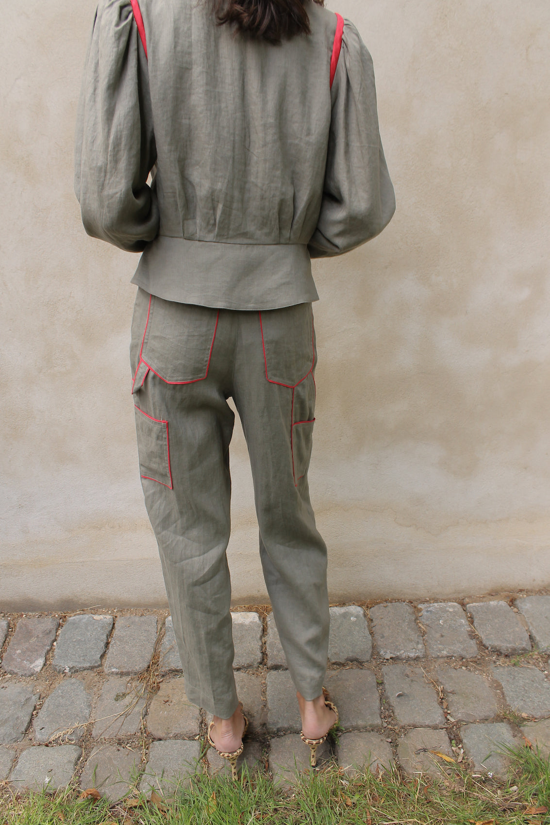 The Emma Pants in Khaki Linen. The pants feature cargo details on the side and large pockets with piping details in a contrasting color. Easily modify the shape of the pants with a button adjustment.  Style them with a t-shirt, blouse, or a matching Emma Jacket in Khaki.  Also available in Orange, Pink and Navy.  Material: 100% linen. Lining: 100% viscose.  The model is 175cm (5'9") and is wearing a size S.