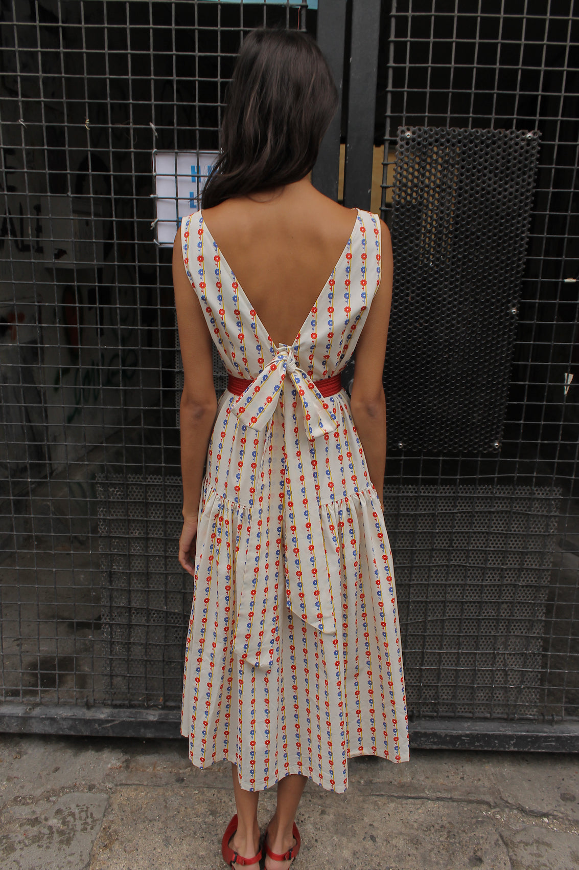 The Sonya Dress is an oversized style with a high neckline and low back featuring a large bow detail. The dress is made in crispy cotton poplin. Style it with an open shirt or denim jacket.  Also available in Navy Flower Poplin, Khaki Poplin, Beaded Emerald Silk Velvet, White Daisy Silk, and Black Silk Velvet.  Material: 100% cotton.  The model is 175cm (5'9") and is wearing a size S.